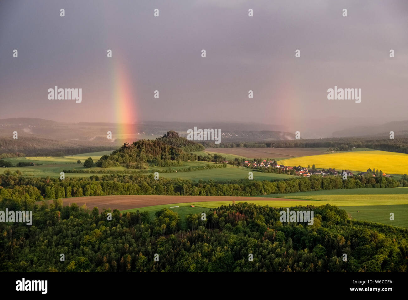 Dunkle Gewitterwolken und ein Regenbogen über die Felsformationen der Sächsischen Schweiz Stockfoto