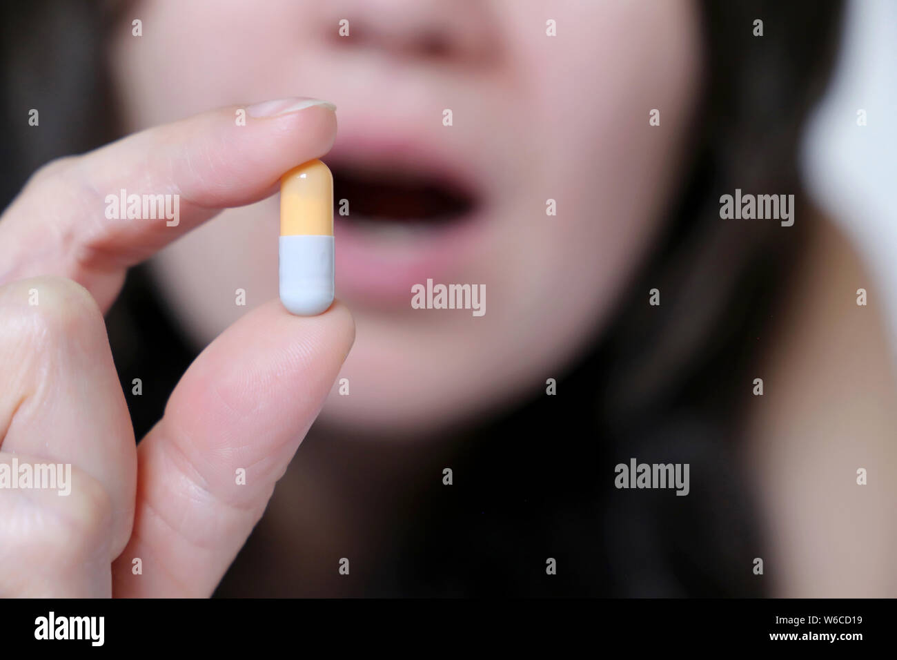 Frau nimmt eine Tablette, Kapsel in weiblicher Hand. Krankes Mädchen mit Medikamente, Schmerzmittel, Antibiotika oder Vitamin Stockfoto