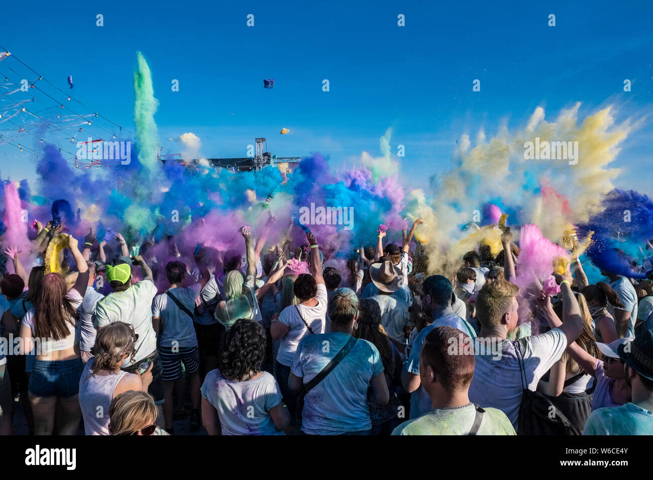 Hunderte von jungen Menschen feiern Holi, das Fest der Farben, werfen Farbe Pulver in der Luft Stockfoto