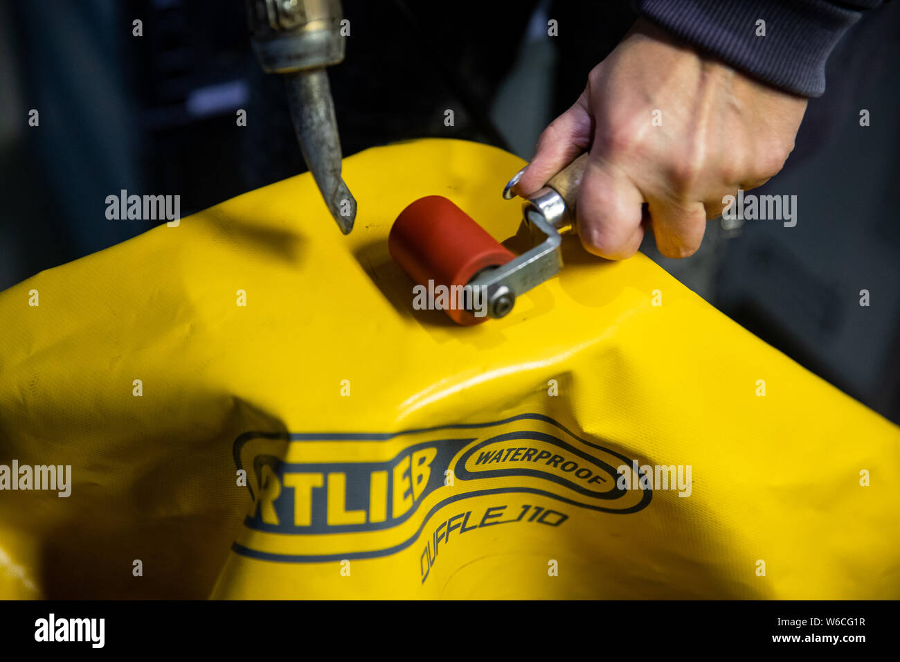 Heilsbronn, Deutschland. 12 Dez, 2018. Ein Mitarbeiter Reparaturen eines Kunden Beutel in der Customer Service Area der wasserdichten Fahrradtasche und Rucksack Hersteller Ortlieb. (Dpa: "Lazy Europäer? Outdoor Hersteller Angst für junge Zielgruppe") Credit: Daniel Karmann/dpa/Alamy leben Nachrichten Stockfoto