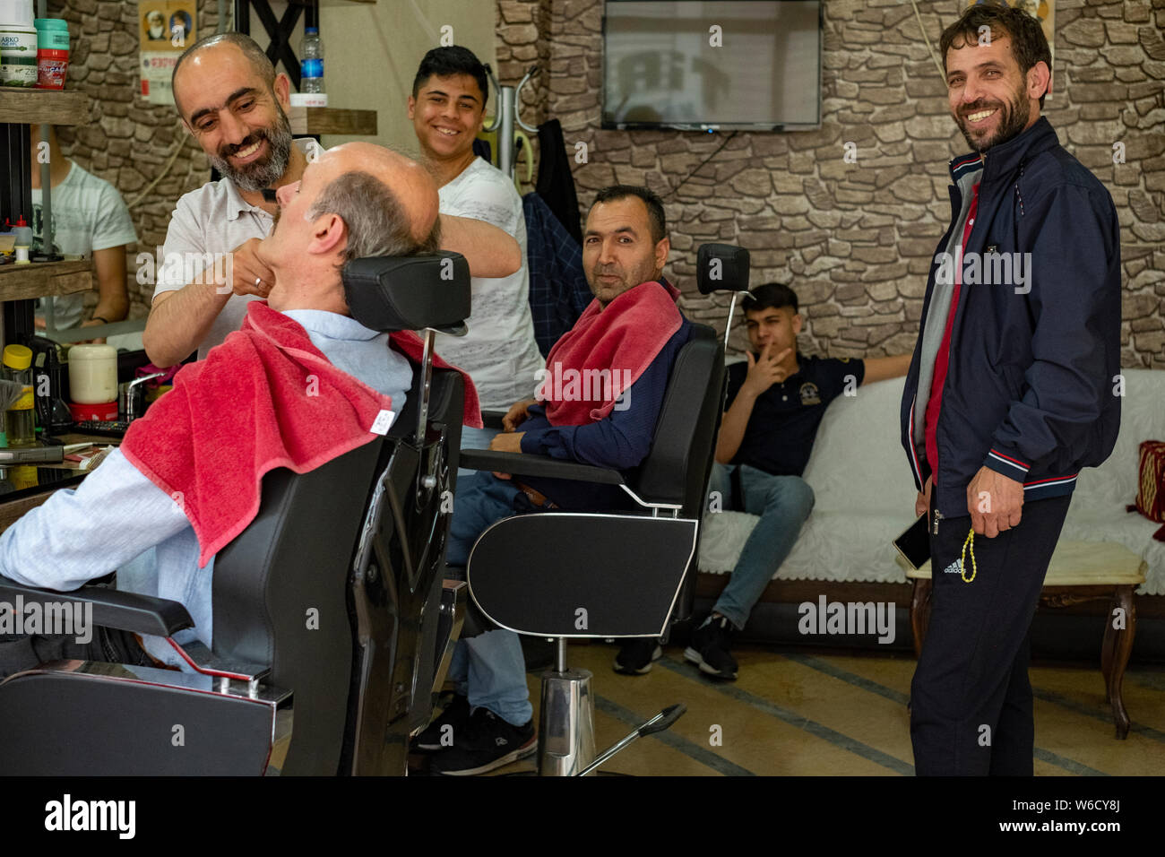 Herrenfriseure bieten ihren Kunden Haarschnitte und rasiert in einem Friseur im Zentrum von Istanbul, Türkei Stockfoto