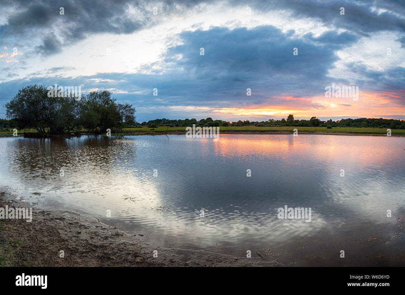 Stürmische Sonnenuntergang über Janesmoor Teich an Fritham im New Forest in Hampshire Stockfoto