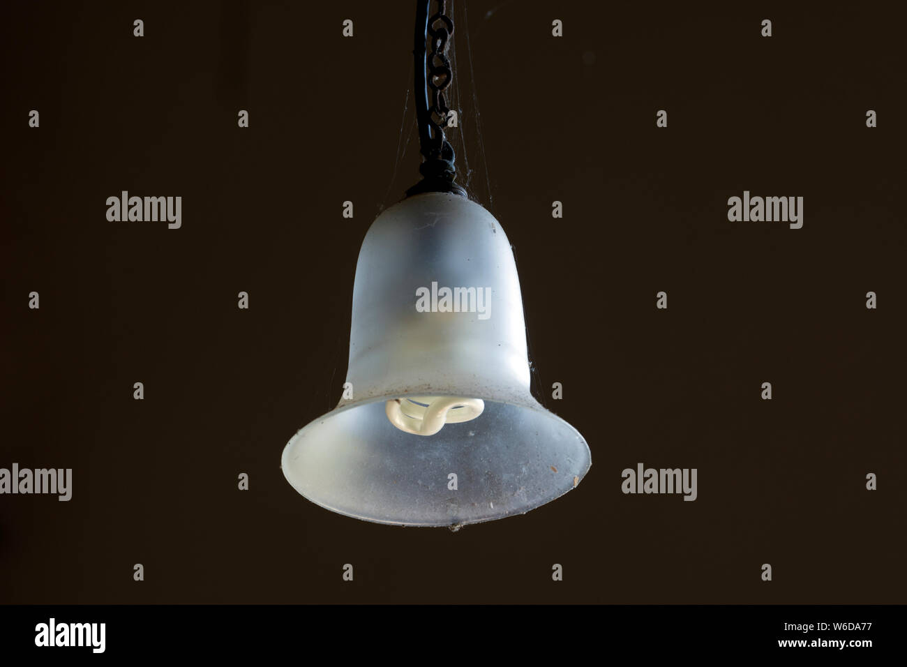 Ein Glas Schatten mit einem long-life Lampe in einer Kirche Stockfoto