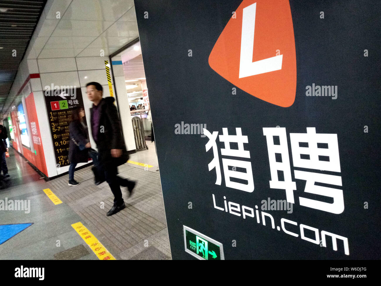 ---- Passagiere vorbei an einer Werbung für Chinesisch Online Recruitment Agency Liepin.com an der U-Bahnstation in Shanghai, China, 1. März 2018. Stockfoto