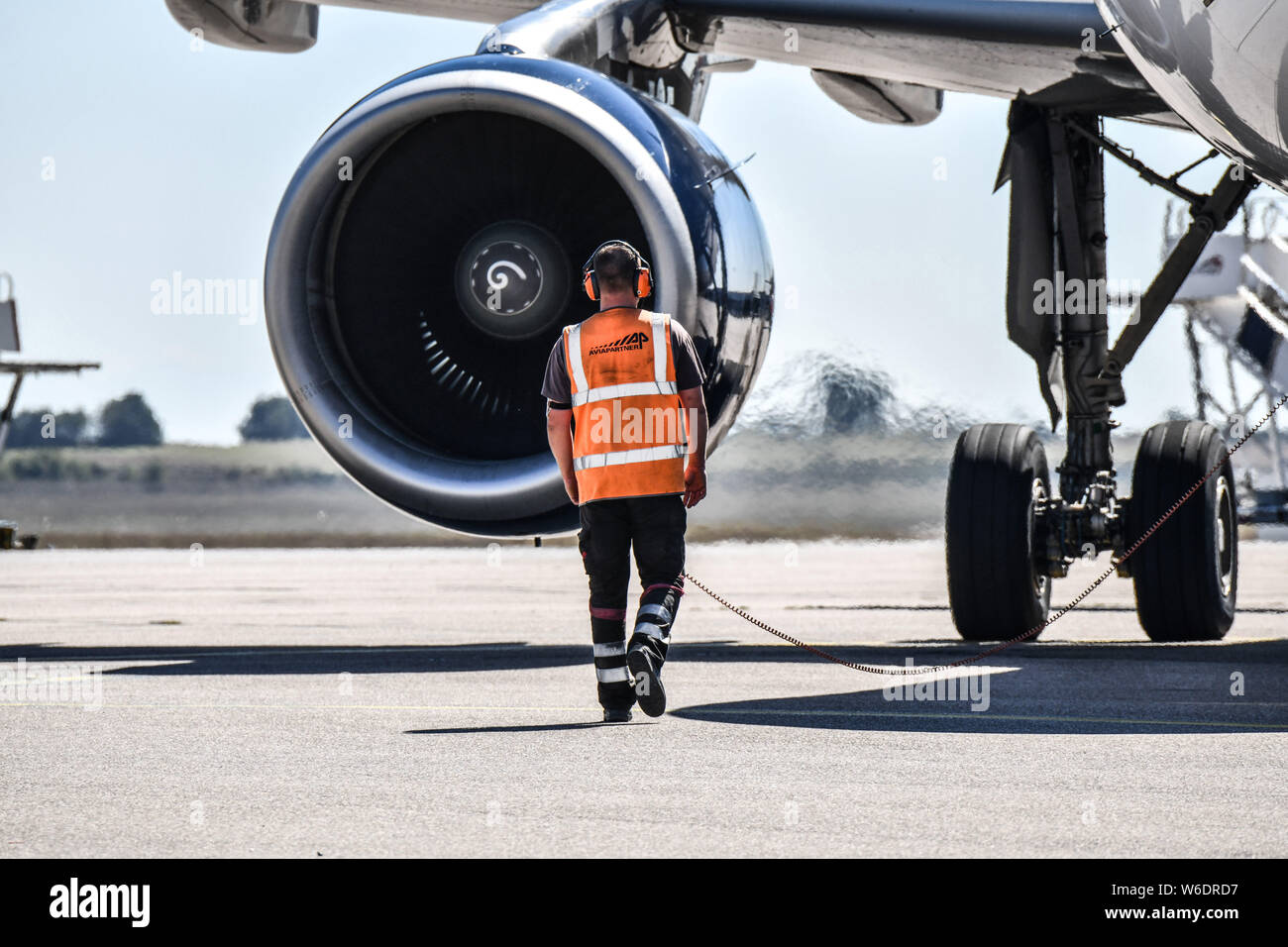 Colombier-Saugnieu (Frankreich). Flughafen Lyon Saint-Exupery. Ein Flughafen Parkwächter tragen ein Gehörschutz in der Nähe von einem Flugzeug Motor auf Stockfoto