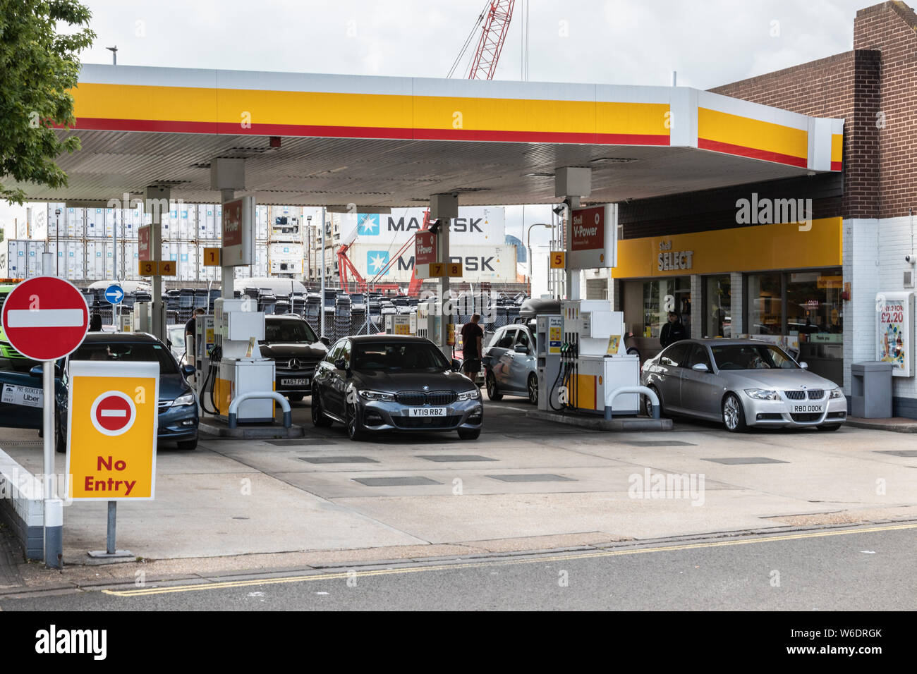 Treiber füllt sich mit Kraftstoff mit einem britischen Shell Tankstelle mit Autos auf dem Vorplatz Stockfoto