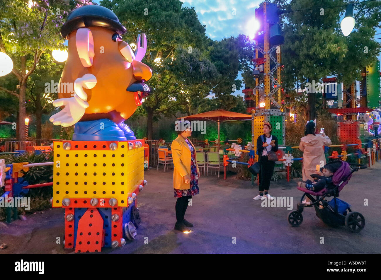 Ein Besucher stellt für Fotos mit einer Skulptur von Frau Potato Head, ein Charakter der animierte Film Pixars "Toy Story", an der 7. Thematische Land, Disney Stockfoto