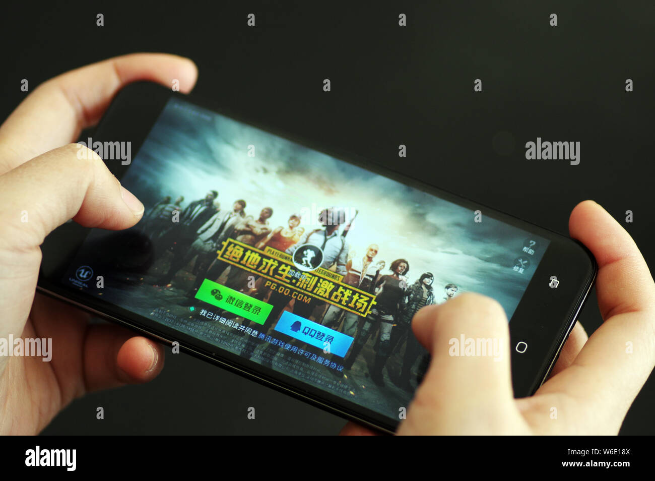 ---- Eine Chinesische mobile Game Player spielt's Tencent multiplayer Online Battle Royale's Spiel PlayerUnknown Schlachtfelder, auf sein Smartphone in Ji'nan Stockfoto