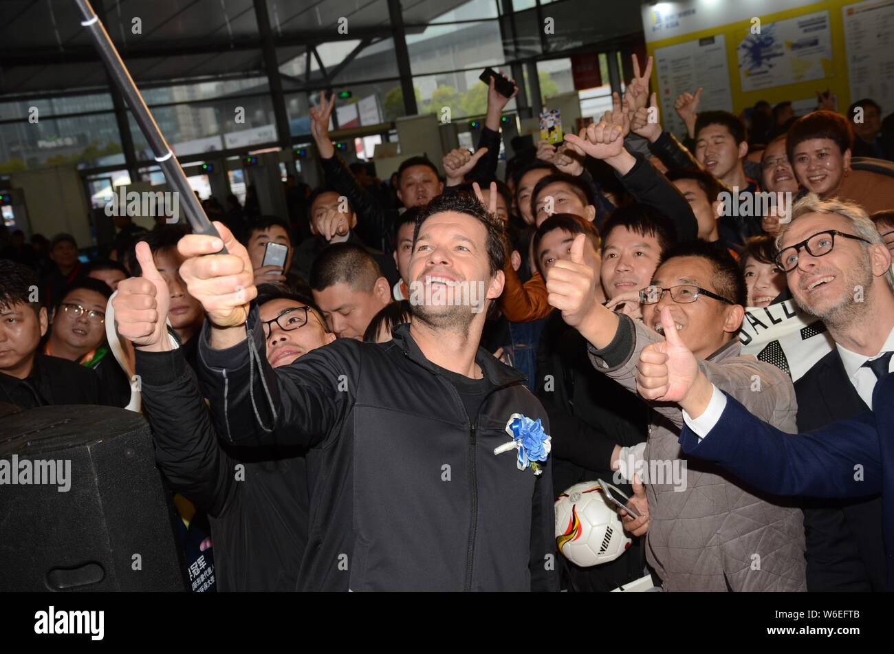 Pensionierter deutscher Fußballspieler Michael Ballack, Front, nimmt selfies mit Fans während einer Pressekonferenz für ausgedehntere Stand der Domotex Shanghai exhibitio Stockfoto