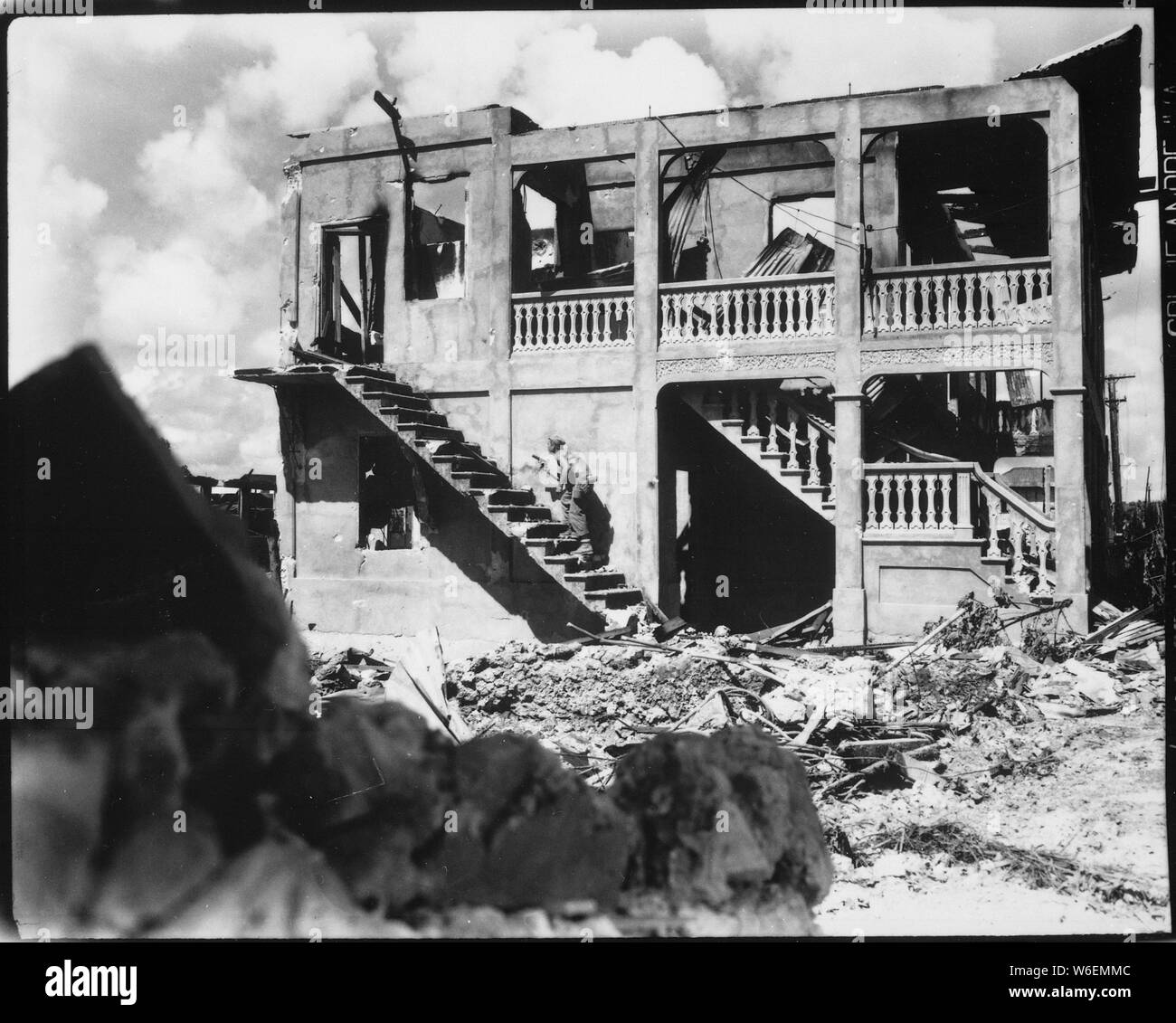 Ein Marine aus dem dritten Geschäftsbereich Marine geht nach einem Sniper in einem mit einer Schale versehenen Gebäude. Guam, August 1944; Allgemeine Hinweise: Verwenden Sie Krieg und Konflikt Nummer 1190 bei der Bestellung eine Reproduktion oder Anforderung von Informationen zu diesem Bild. Stockfoto