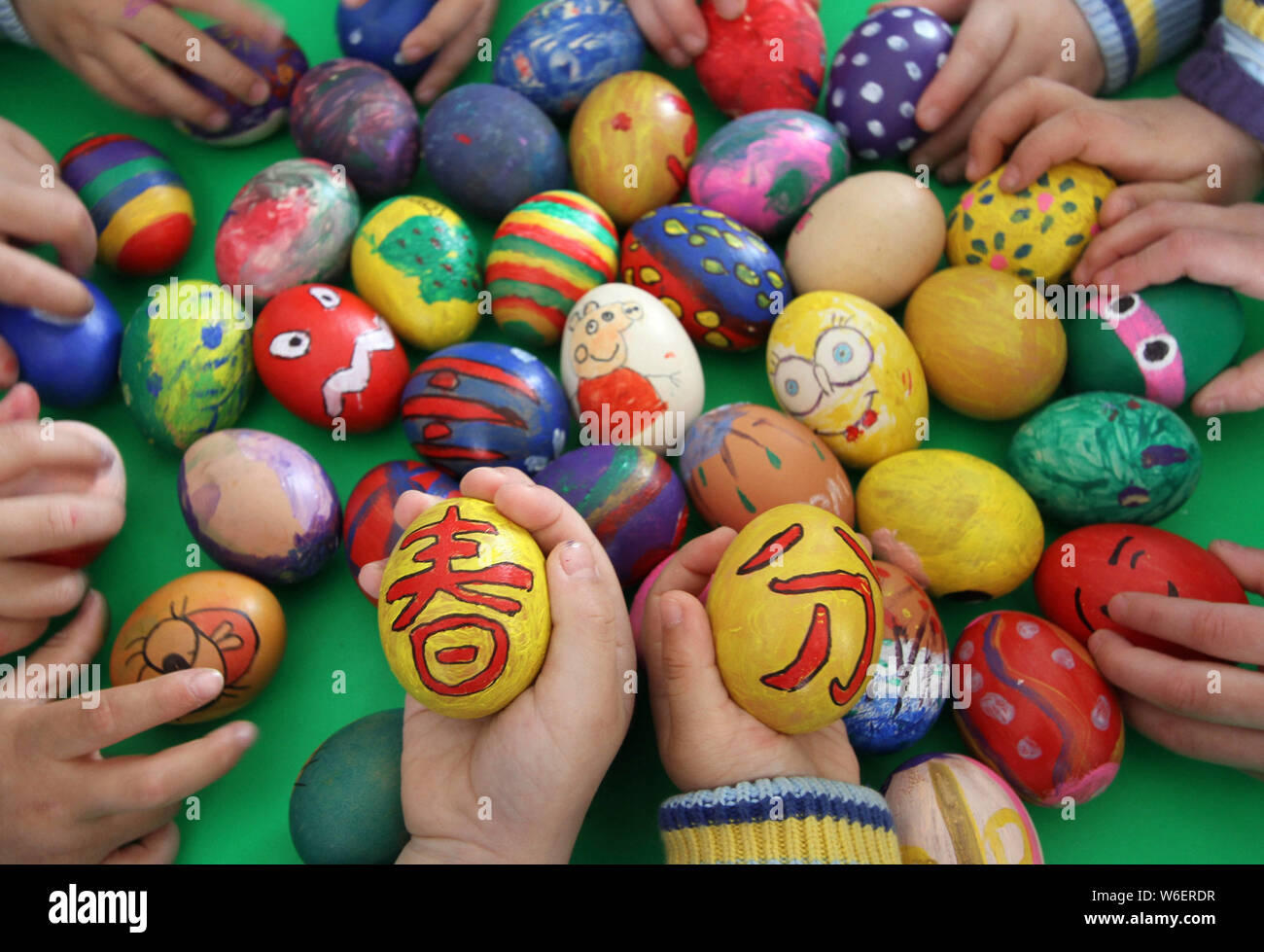 Kinder zeigen Eier mit chinesischen Zeichen und Farben zum Markieren der Tag der "Chunfen' (Frühlingspunkt oder Tagundnachtgleiche) in einem Kindergarten in Han Stockfoto