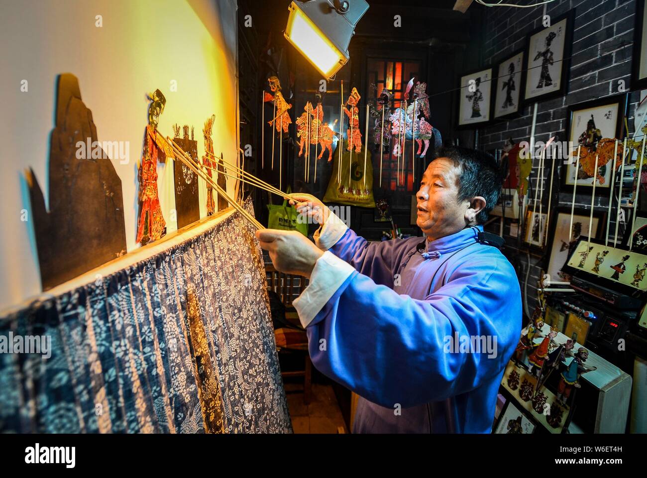 Der 60-jährige Chinese Folk Künstler Chen Shouke führt shadow play oder schattenpuppenspiel, auch bekannt als Shadow Puppet, in Tai'erzhuang Bezirk, Zaozhuang Stockfoto