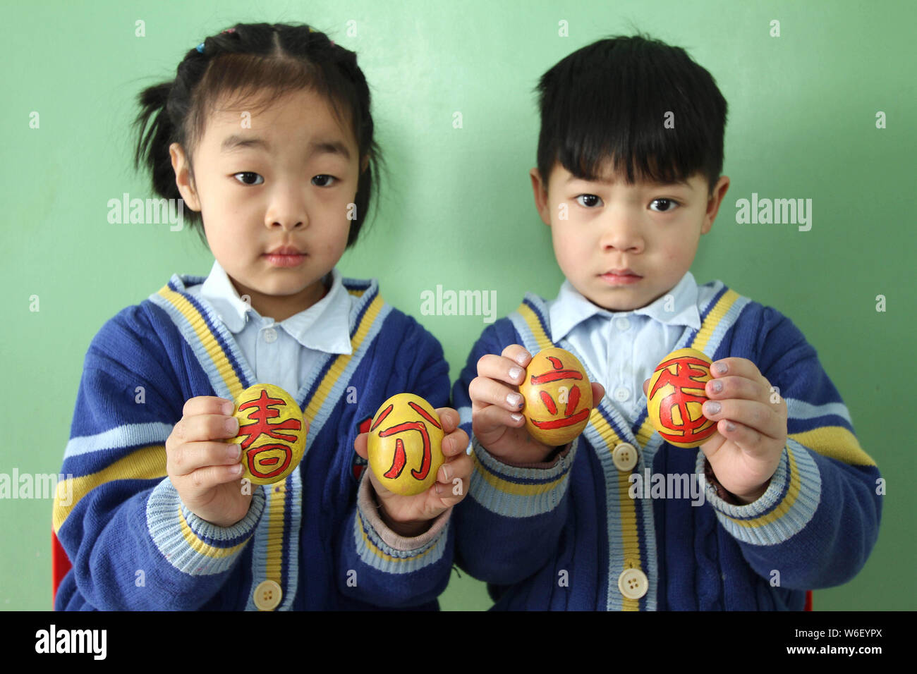 Kinder zeigen Eier mit chinesischen Zeichen und Farben zum Markieren der Tag der "Chunfen' (Frühlingspunkt oder Tagundnachtgleiche) in einem Kindergarten in Han Stockfoto