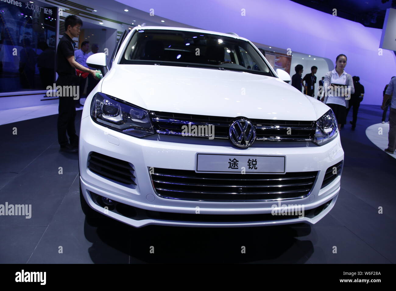 ---- Ein Arbeitnehmer Stäube aus einer importierten Touareg SUV von Volkswagen auf dem Display während der 12 China (Guangzhou) Internationale Automobil Ausstellung, Kno Stockfoto