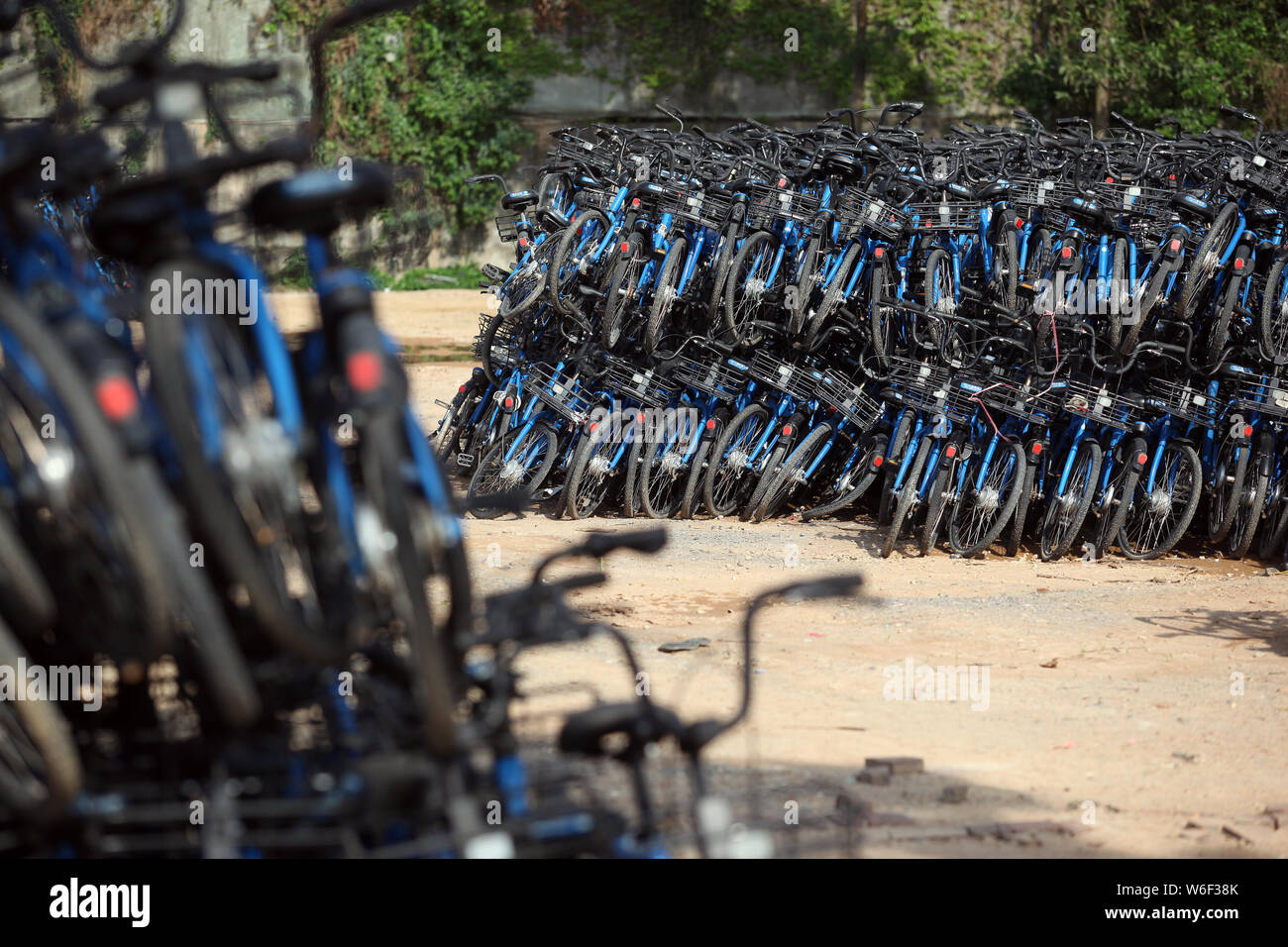 Ein Blick auf Bluegogo Gemeinschafts-Fahrräder der chinesischen Taxifahrer hageln und Car-sharing service Didi Chuxing cramming einen Parkplatz in Shenzhen City, South China Stockfoto