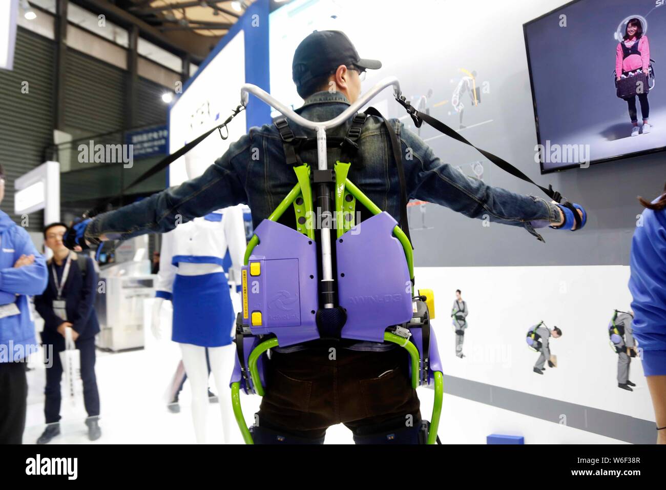 Ein Besucher versucht, einen Robotischen Exoskelett während der Electronica China 2018 in Shanghai, China, 15. März 2018. Einen robotischen Exoskelett, Th lassen können Stockfoto