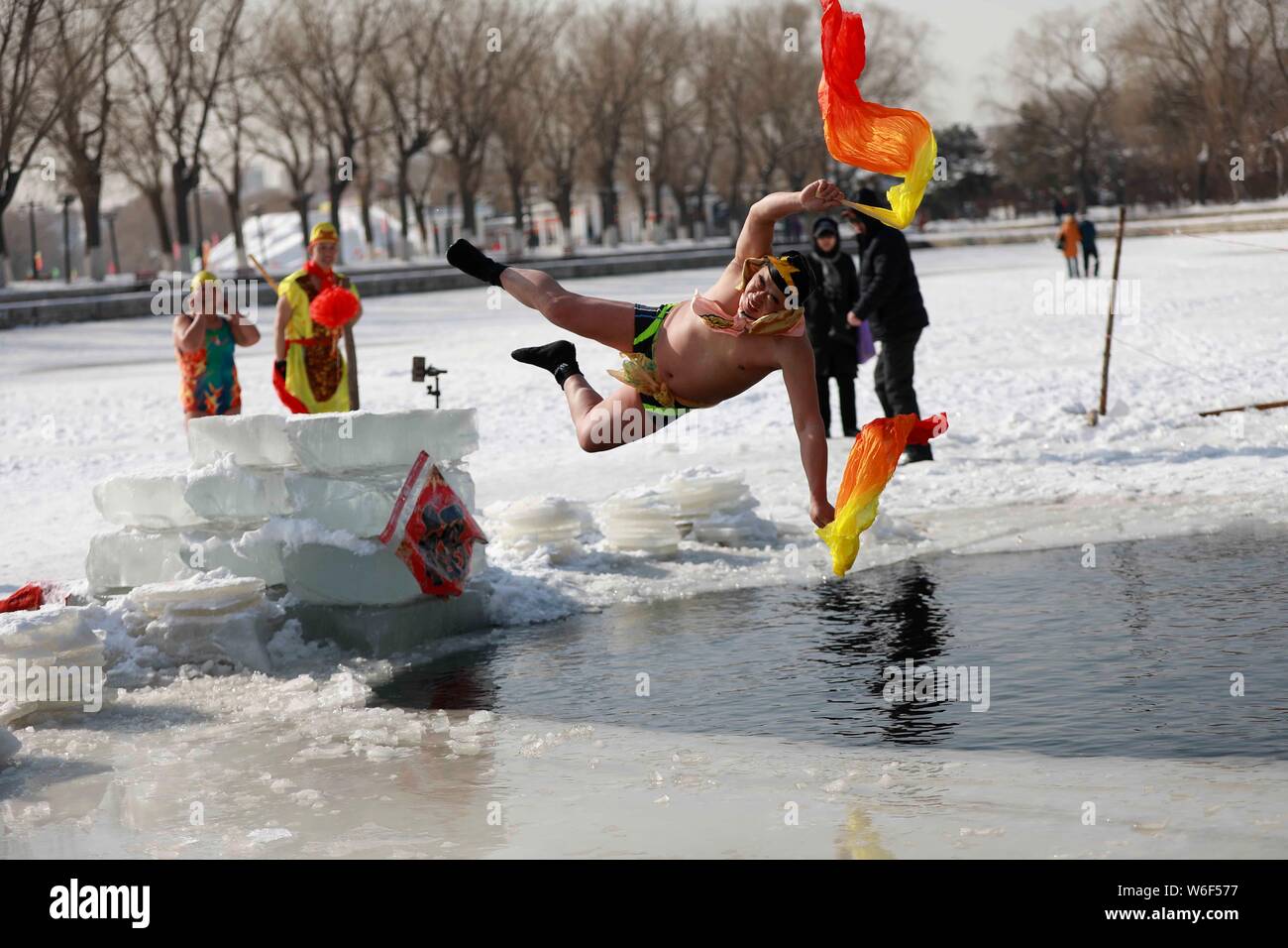 Eine chinesische Winter schwimmen Enthusiasten in das Kostüm von Zhu Bajie, einem wichtigen Charakter des Romans die Reise nach Westen gekleidet, führt lustig Tauchen in Stockfoto