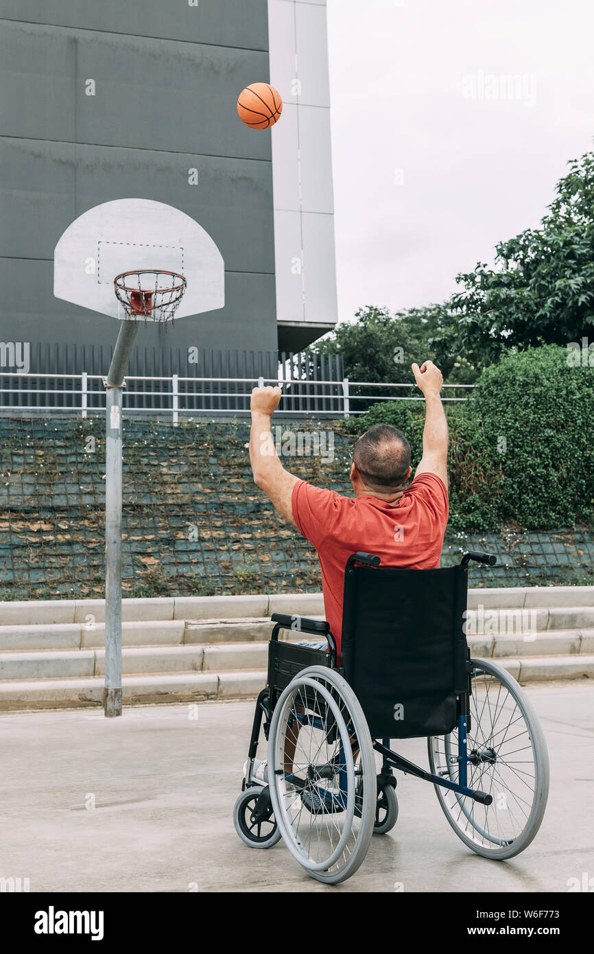 Behinderte Menschen im Rollstuhl Basketball allein spielen in der Stadt, das Konzept der adaptiven Sport und körperliche Aktivität, Rehabilitation für Menschen mit Phys Stockfoto