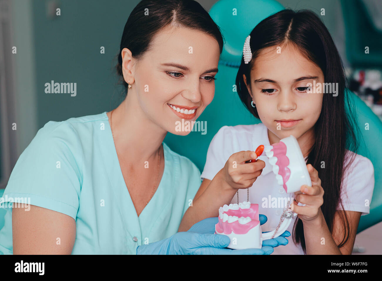 Gemischte Rasse Mädchen zeigen, wie zu Ihrem Zahnarzt die Zähne zu putzen, während eine zahnmedizinische Verabredung Stockfoto