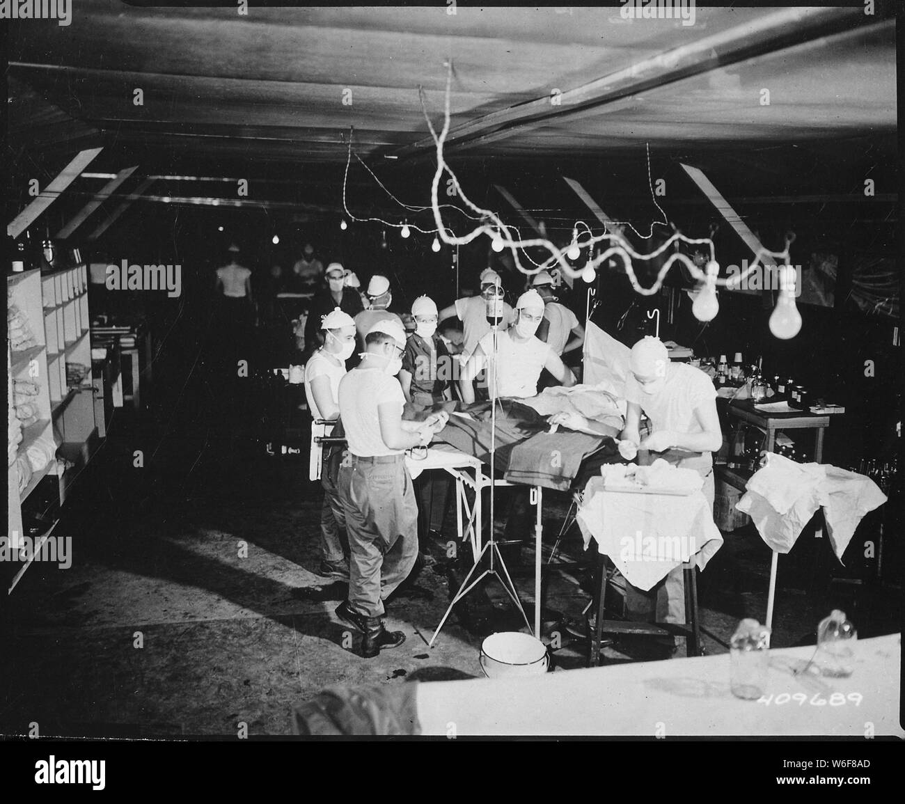 Eine Operation ist ein verwundeter Soldat an der 8209Th Mobile Army Surgical Hospital durchgeführt, 20 Meilen von den vorderen Linien.; Allgemeine Hinweise: Verwenden Sie Krieg und Konflikt Nummer 1458 bei der Bestellung eine Reproduktion oder Anforderung von Informationen zu diesem Bild. Stockfoto