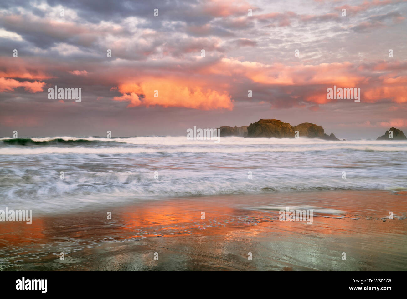 Abend glühen auf den vielen sea Stacks an den Bandon Beach inklusive Offshore Face Rock und Hut des Assistenten an der südlichen Küste von Oregon. Stockfoto