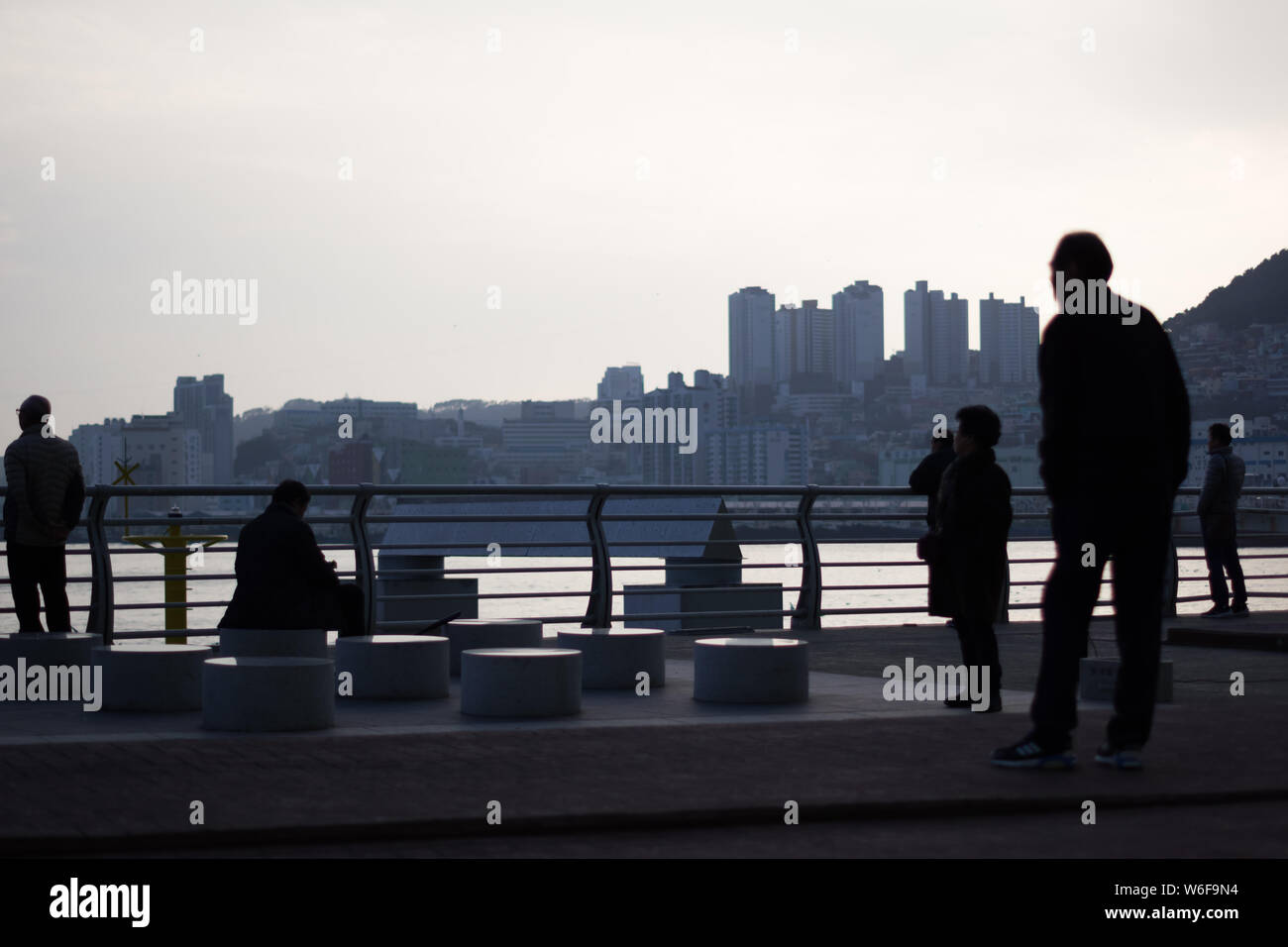 Busan, Korea, 22.12.2018, Silhouette von Menschen in Busan Hafen bei Sonnenuntergang. Stockfoto