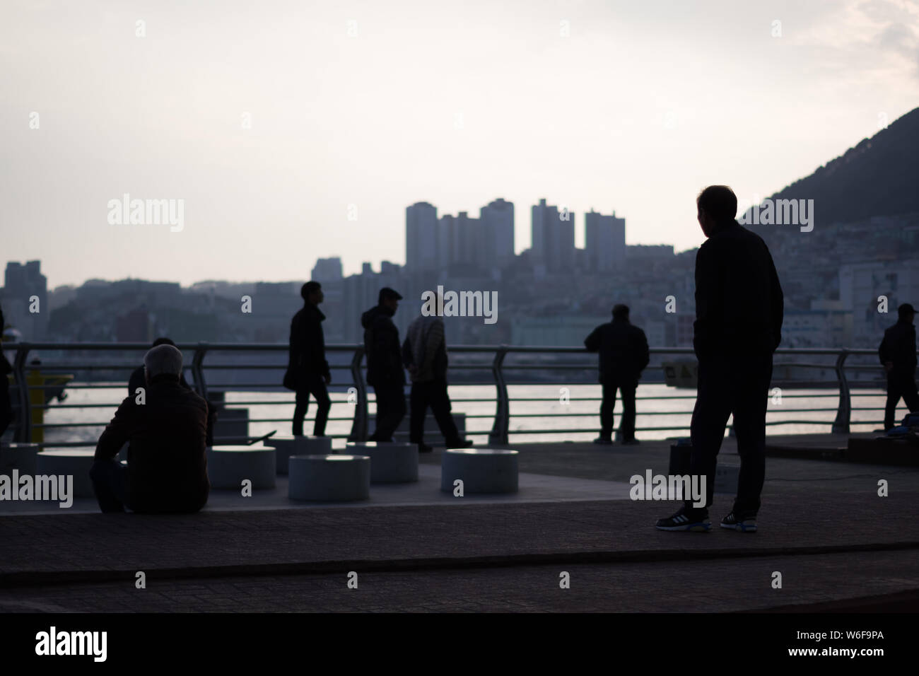 Busan, Korea, 22.12.2018, Silhouette von Menschen in Busan Hafen bei Sonnenuntergang. Stockfoto