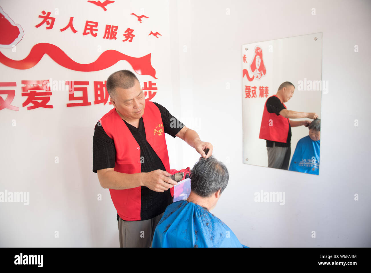 (190801) -- SHENGZHOU, August 1, 2019 (Xinhua) - ein Freiwilliger schneidet Haare für einen älteren Bürger an einer Nachbarschaft in Shengzhou, der ostchinesischen Provinz Zhejiang, Aug 1, 2019. "Neighbor plus' ist eine kreative Art und Weise zu fördern lokale Bewohner in Gemeinschaft Volunteer Service in Shengzhou zu beteiligen, und hat über 600 Familien die Teilnahme am Programm, ihre Nachbarn zu Hilfe angezogen. (Xinhua / Weng Xinyang) Stockfoto