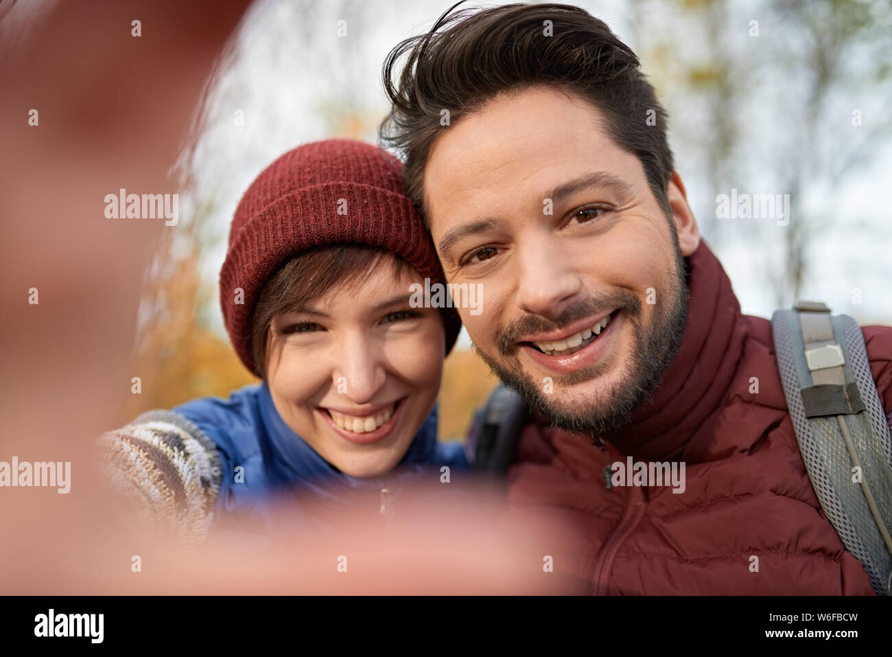 Paar der kanadischen Millennials selfies nehmen mit einem Smartphone in einem Fall Forrest Stockfoto