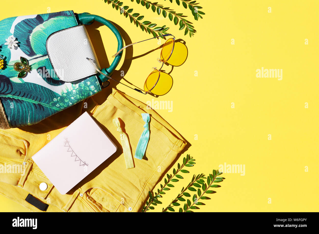 Frau Sommer Strand Mode Accessoires und Kleidungsstücke auf gelbem Hintergrund Stockfoto