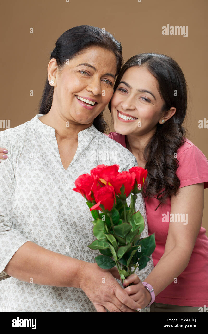Teenager Mädchen geben Blumenstrauß zu ihrer Mutter Stockfoto