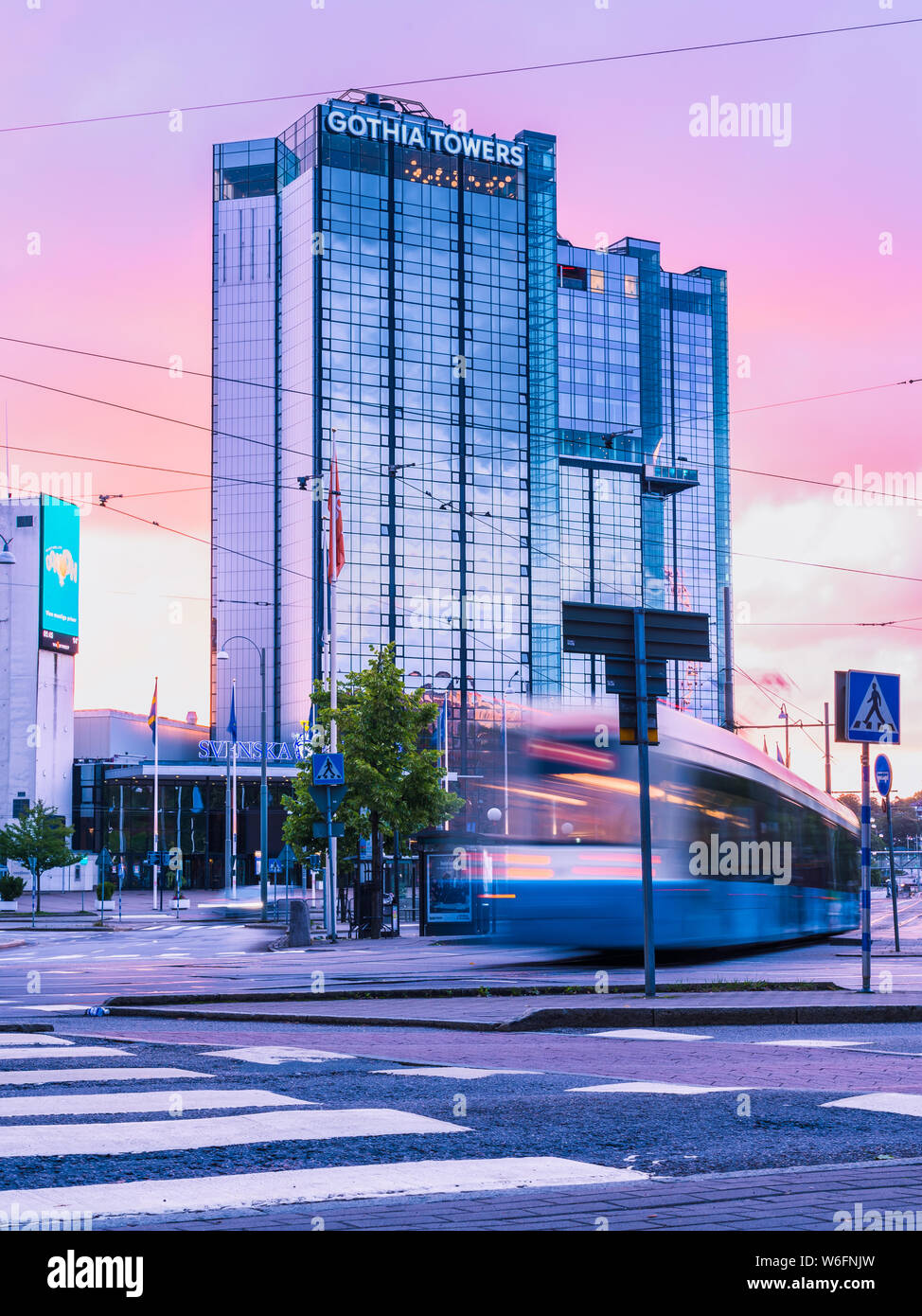 13/08-17, Göteborg, Schweden. Die erste Straßenbahn der Tag ist vorbei auf den normalerweise stark befahrenen Straße von korsvägen. Die violetten Himmel ist im Glas reflektiert. Stockfoto