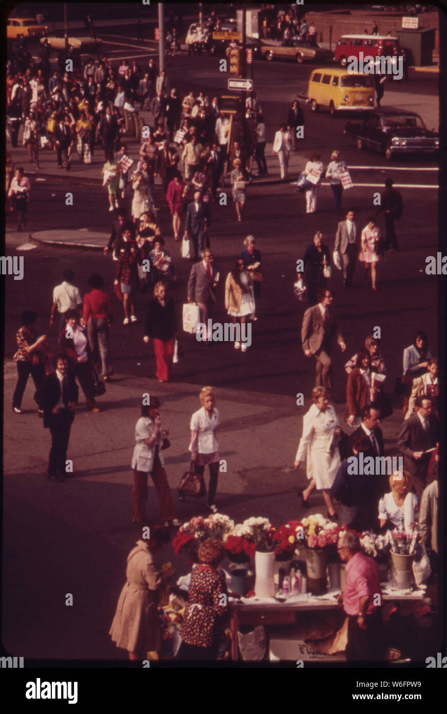 Pendler KOPF FÜR ZU HAUSE Bei Rush Hour in der Nähe der Docks von der Staten Island Fähre im Battery Park, MANHATTAN. Einige PAUSE eine Blume - Verkäufer' Stockfoto