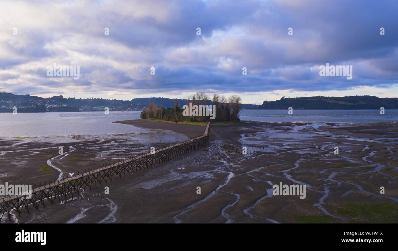 Luftaufnahme der ikonischen Aucar Insel, eine Brücke aus Holz. Diese Insel liegt in der Nähe der Stadt Quemchi in der Chiloé Archipel Stockfoto