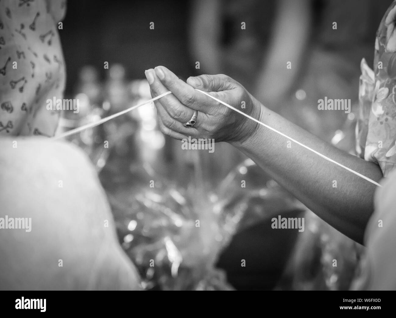 Hand heiligen Thread in Thai Ritus, Schwarz/Weiß-Bild Stockfoto