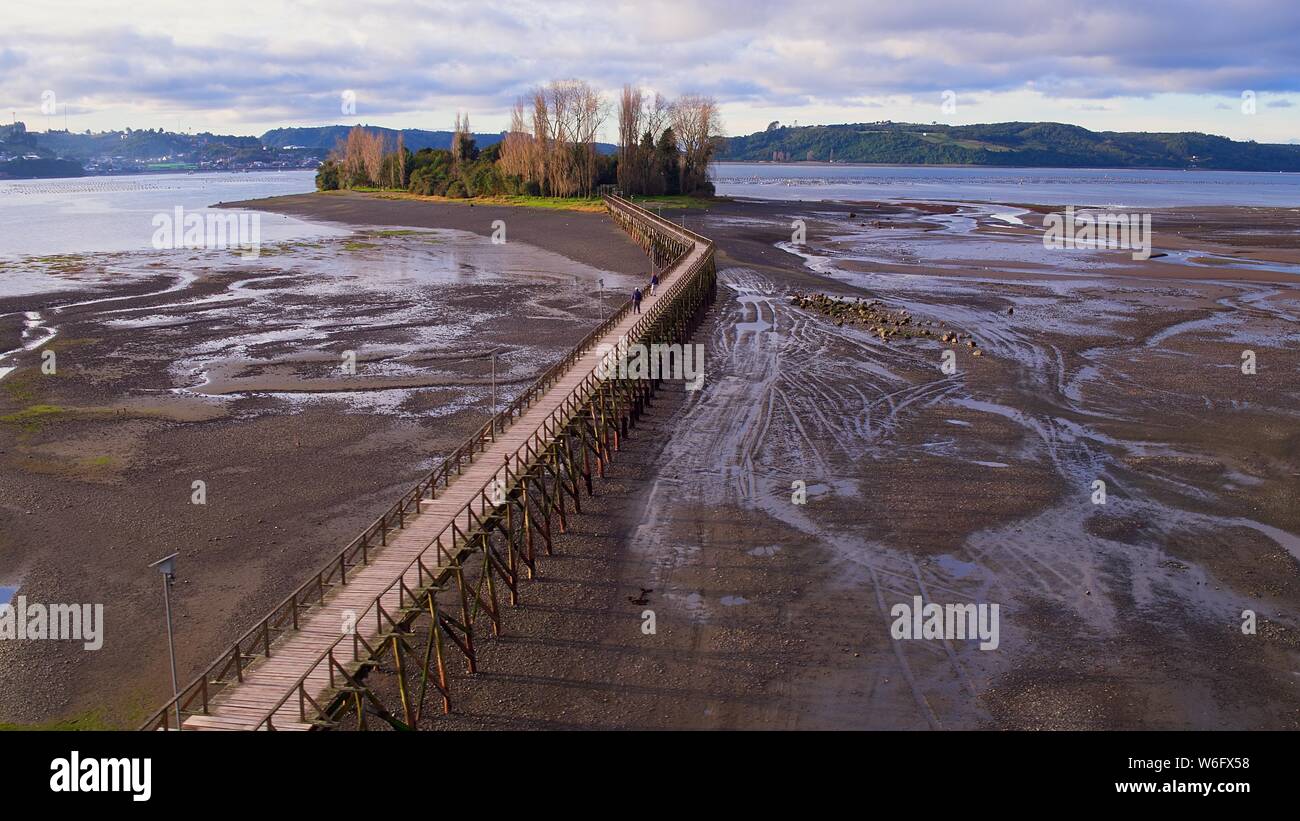 Luftaufnahme der ikonischen Aucar Insel, eine Brücke aus Holz. Diese Insel liegt in der Nähe der Stadt Quemchi in der Chiloé Archipel Stockfoto