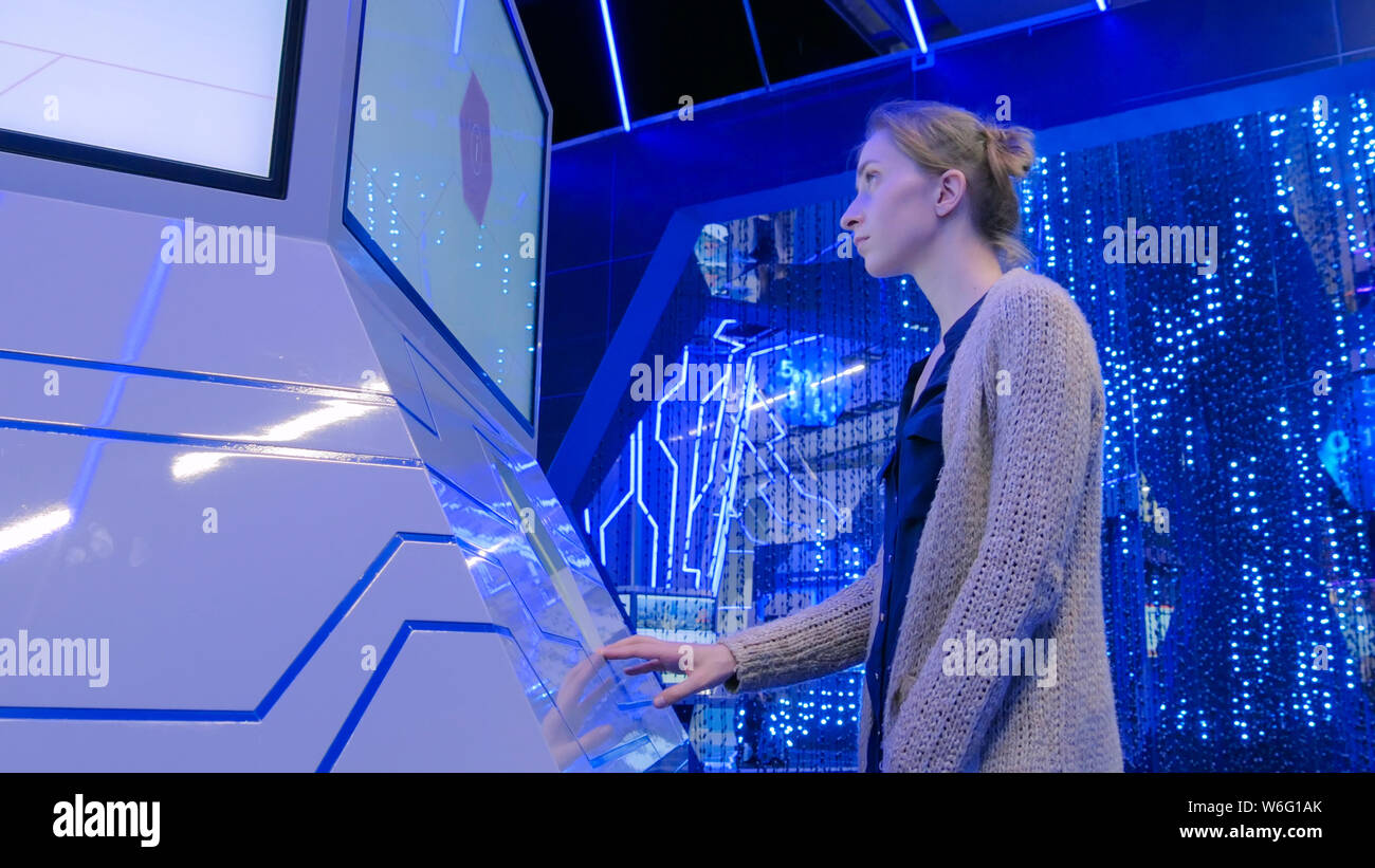 Frau mit interaktiven Touchscreen Display an den städtischen Ausstellung Stockfoto