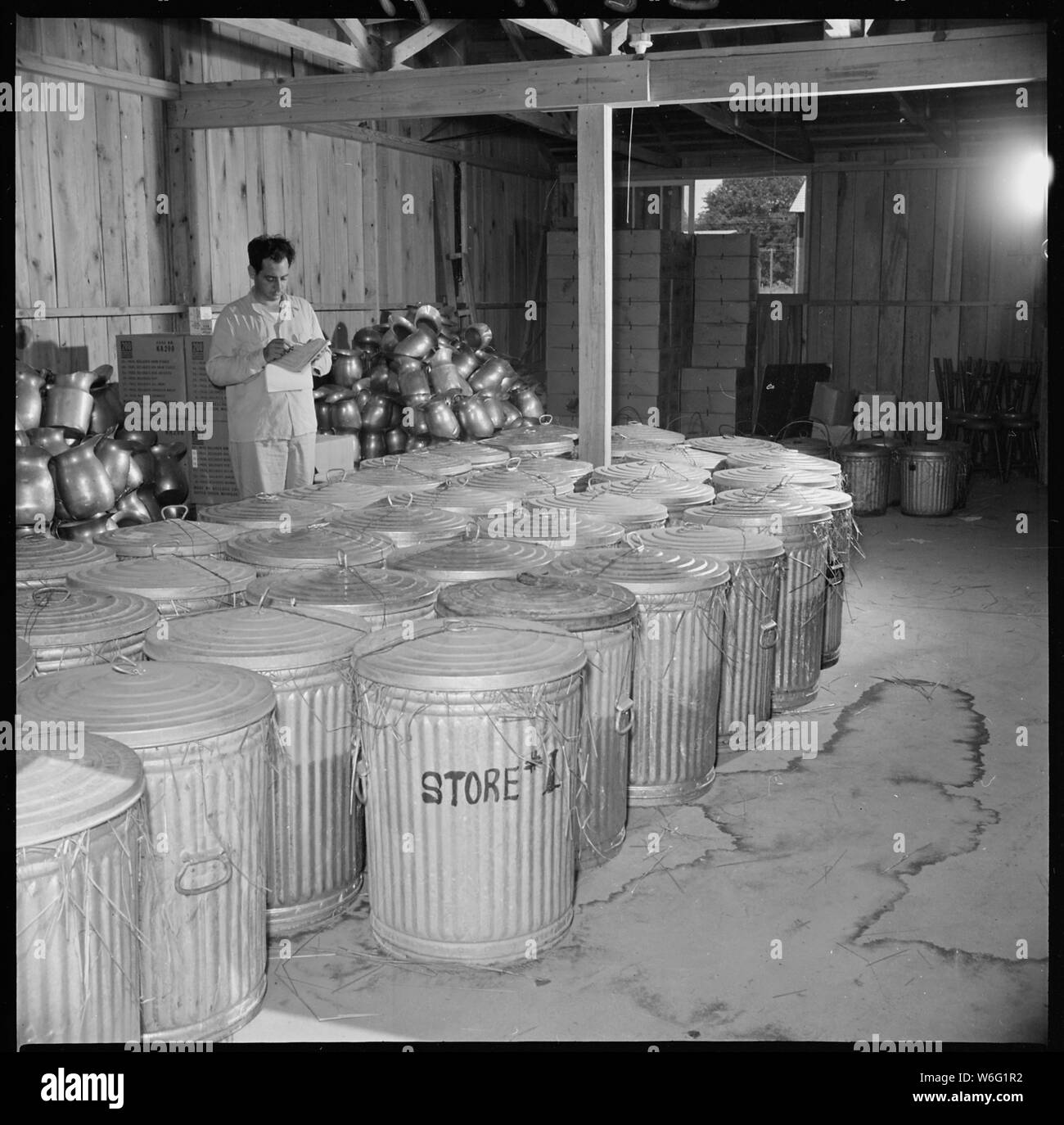 Schließen der Jerome Relocation Center, Denson, Arkansas. Gerichte aus der Mitte dreißig - drei mich. . .; Umfang und Inhalt: Der vollständige Titel für dieses Foto lautet: Schließen der Jerome Relocation Center, Denson, Arkansas. Gerichte aus der Mitte dreißig - drei Chaos Hallen wurden sorgfältig im Stroh verpackt und in G.I. Dosen für den Versand bereit. Angelo Girardo der Denver Büro gezeigt wird die Aufsicht über die Arbeiten. Stockfoto