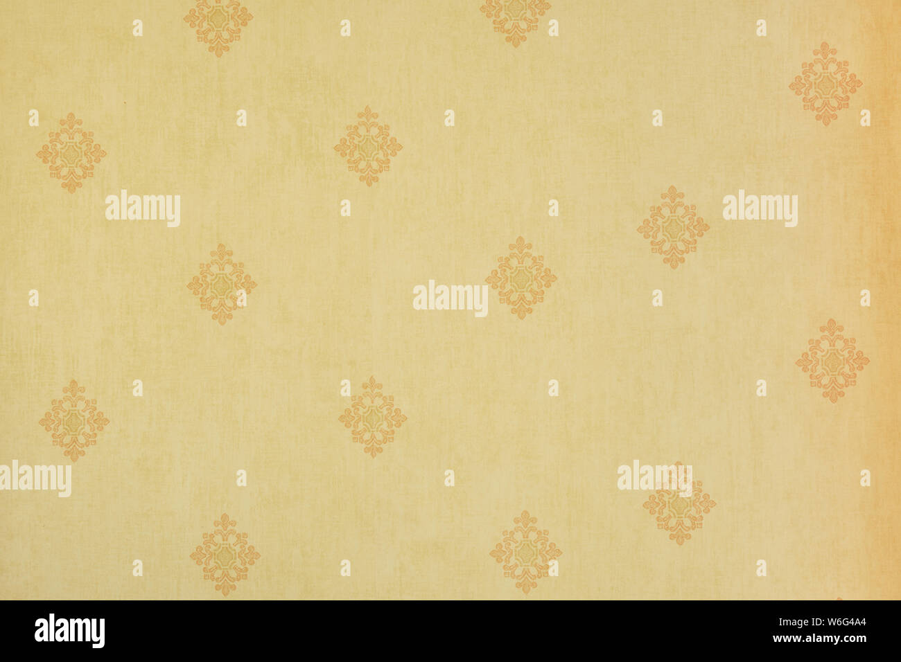 Abstract beige Blumenmuster auf eine leichte gelbe Wand - Struktur, Textur, repetitiv. Stockfoto