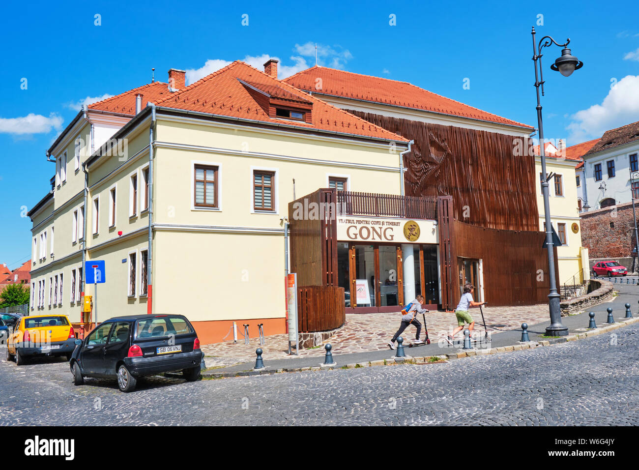 Sibiu, Rumänien - 12. Juli 2019: Gong Theater für Kinder und Jugendliche  (Teatrul pentru Copii si Tineret Gong) mit zwei Kinder auf Tretroller, Pa  Stockfotografie - Alamy