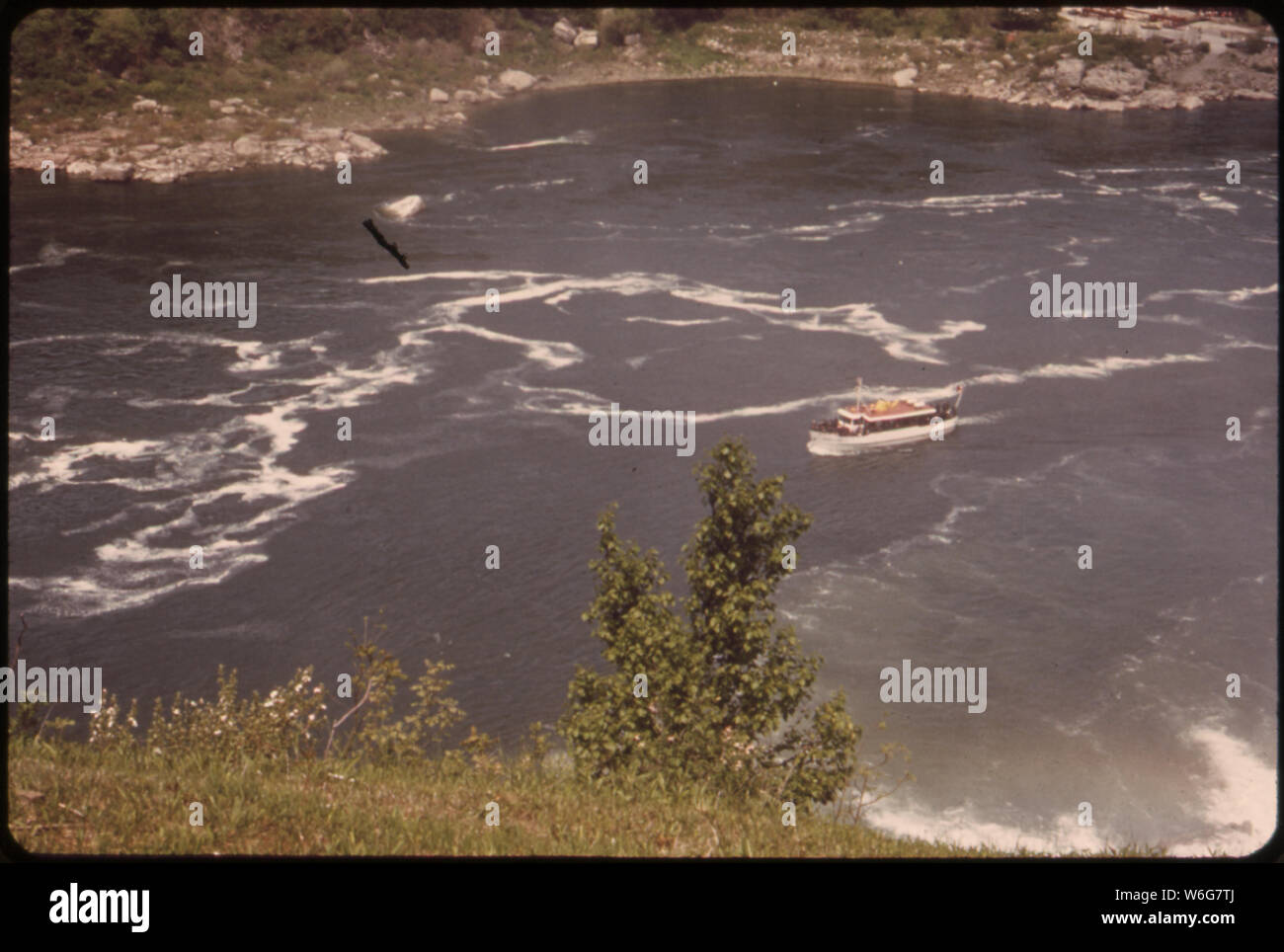 DIESEL-MAID-NEBEL AUSFLUGSBOOT lagen den Niagara River direkt unter den Wasserfällen. Schaum Muster zeigt an, daß die Verschmutzung durch Abwässer und sonstige Abfälle Stockfoto