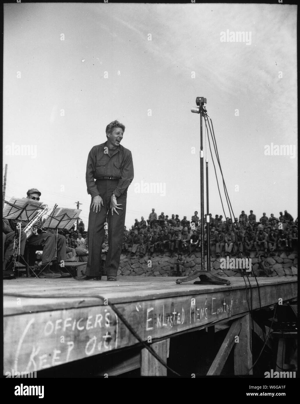 Danny Kaye, berühmte Bühnen- und Star, unterhält 4.000 5th Marine Division Besatzungstruppen in Sasebo, Japan. Die krude Zeichen über die Vorderseite der Bühne sagt: die Beamten heraus halten! Die Soldaten Land.; Allgemeine Hinweise: Verwenden Sie Krieg und Konflikt Nummer 903 bei der Bestellung eine Reproduktion oder Anforderung von Informationen zu diesem Bild. Stockfoto