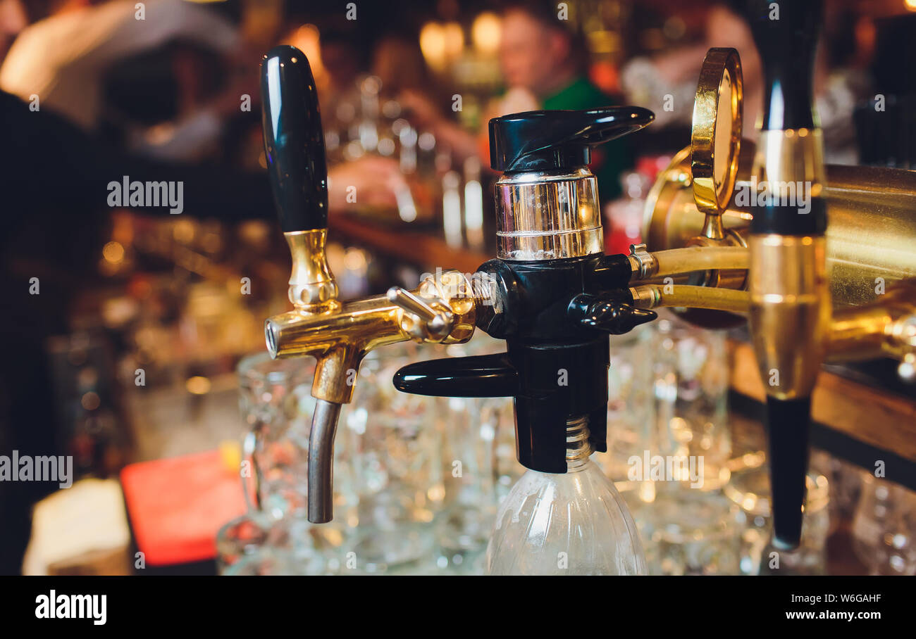 Das Bier in einem Pub. Tippt niemand. Selektive konzentrieren. Alkohol Konzept. Vintage Style. Bier Handwerk. Bar Tisch. Stahl Armaturen. Glänzende Gewindebohrer. Stockfoto