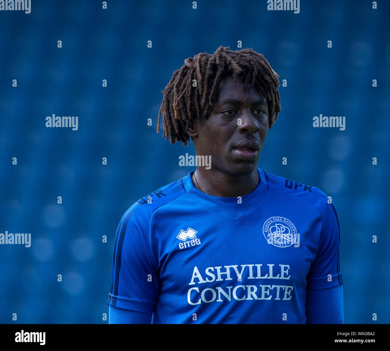 Kopf und Schultern Image der jungen Stürmer Ebere Eze von Queens Park Rangers FC blau Training Kit. Unscharf blaue Sitze im Hintergrund. Stockfoto