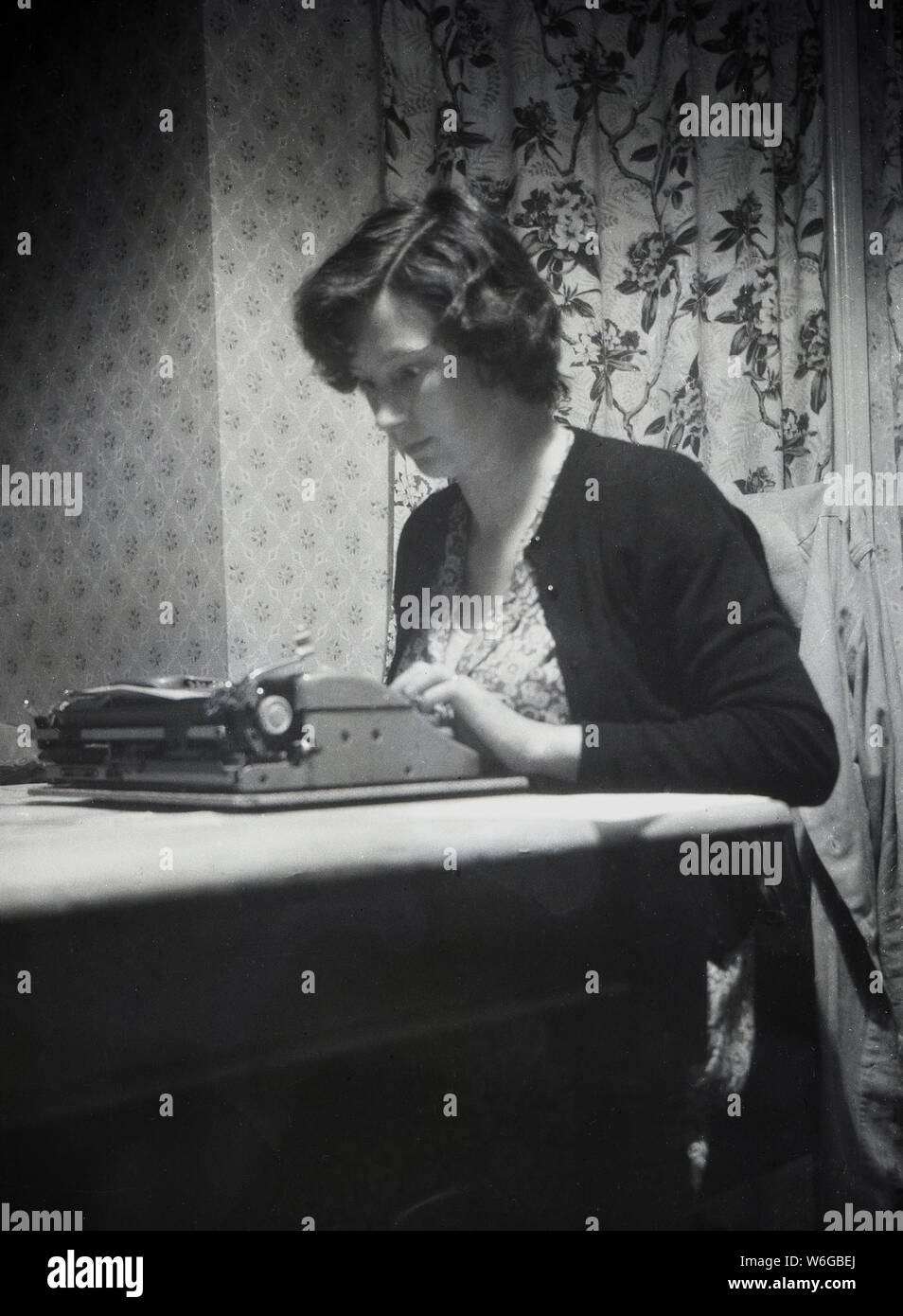 1950, historische, eine junge Frau, die an einem Tisch mit der Schreibmaschine, England, Großbritannien sitzen. Stockfoto