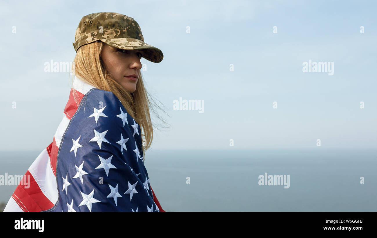 Zivile Frau in Military Cap ihres Mannes. Eine Witwe mit der Flagge der Vereinigten Staaten ohne ihren Mann. Tag des Gedenkens an die gefallenen Soldaten in Th Stockfoto