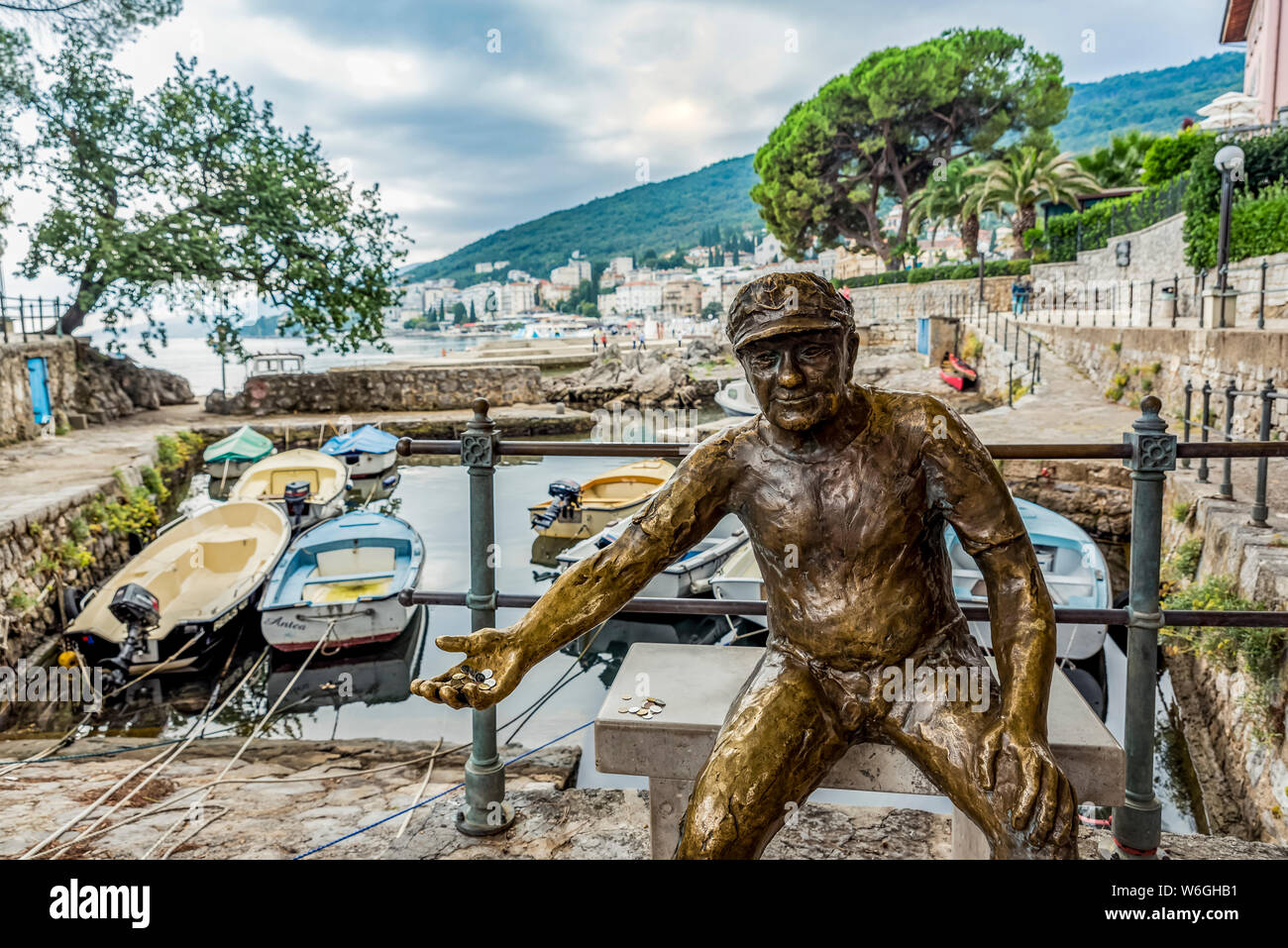 Fischer Skulptur mit Münzen in der Hand in einem Hafen; Opatija, Primorje-Gorski Kotar County, Kroatien Stockfoto