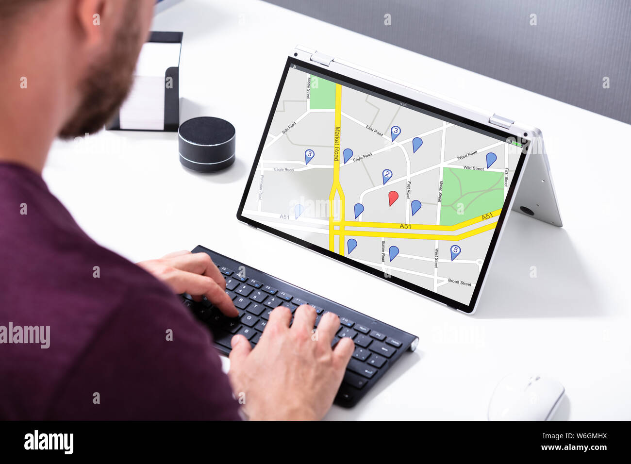 Nahaufnahme eines Mannes, der mit Hilfe von GPS-Karte mit Navigation Zeiger auf Laptop Stockfoto