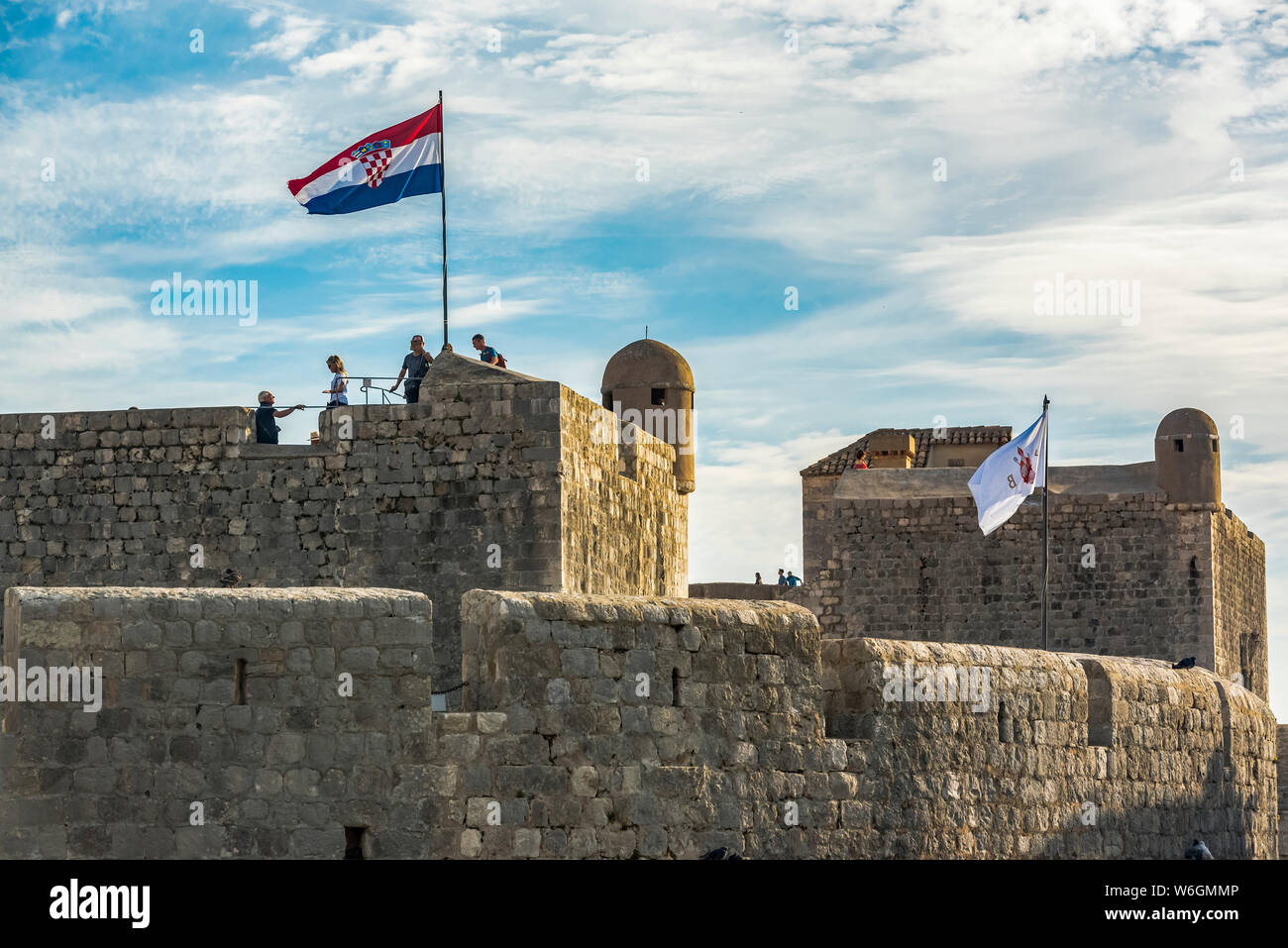 Touristen auf den Mauern eines historischen fortication mit Flagge; Dubrovnik, Grafschaft Dubrovnik-Neretva, Kroatien Stockfoto