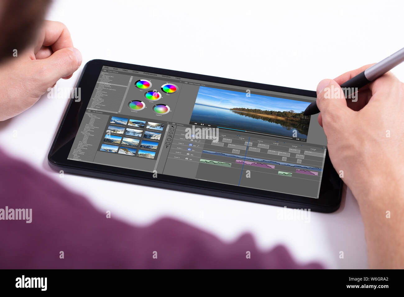 Junge männliche editor Videobearbeitung auf Tablet am Arbeitsplatz Stockfoto